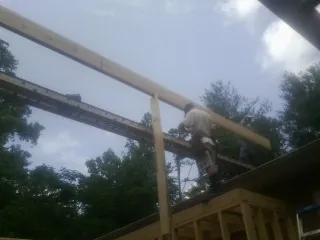 Carpenter setting a ridge beam over a new addition frame — Ice Dam Removal by Roofing Brothers in Notus